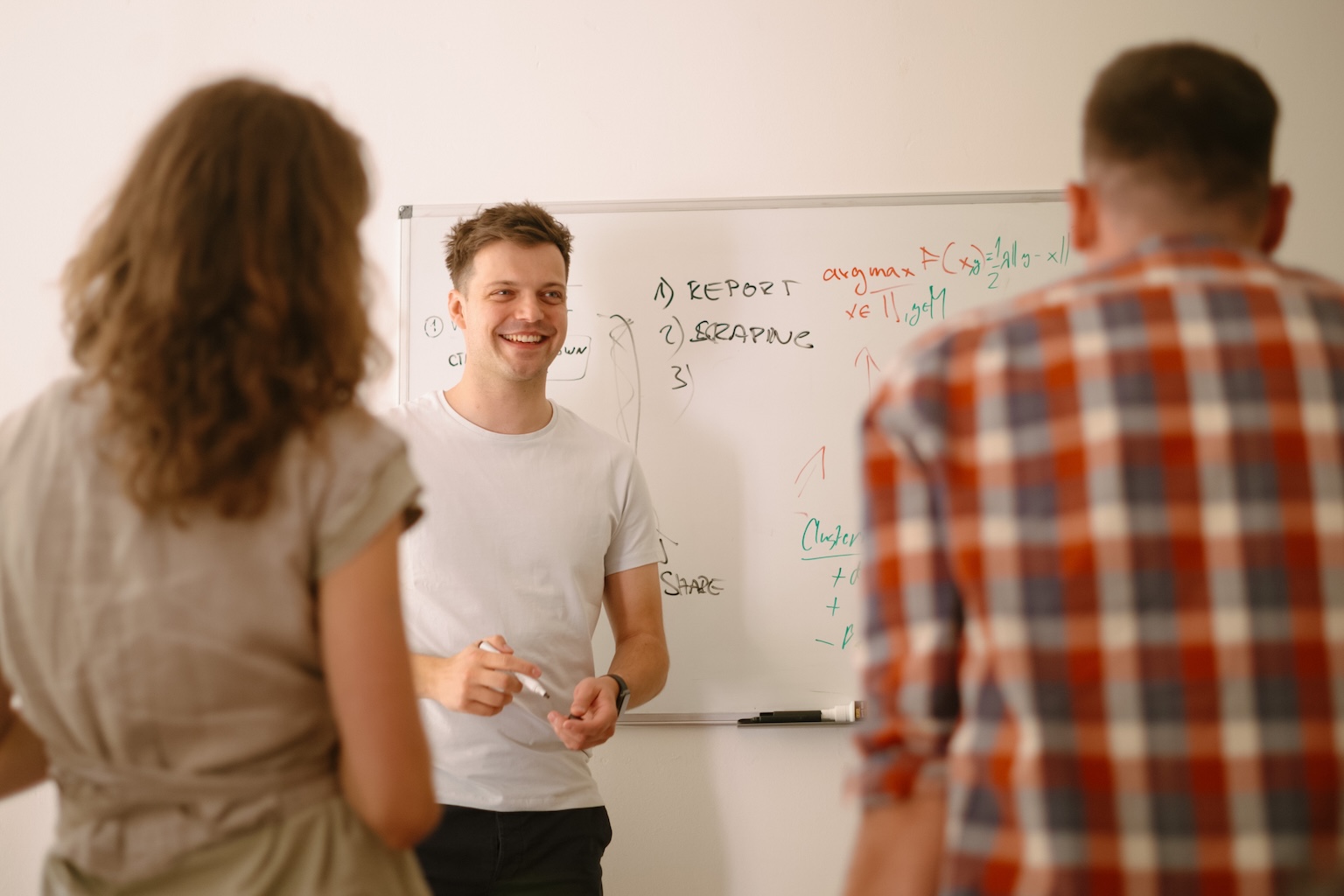 The Aim team selfie - six team members smiling together outside a modern office building